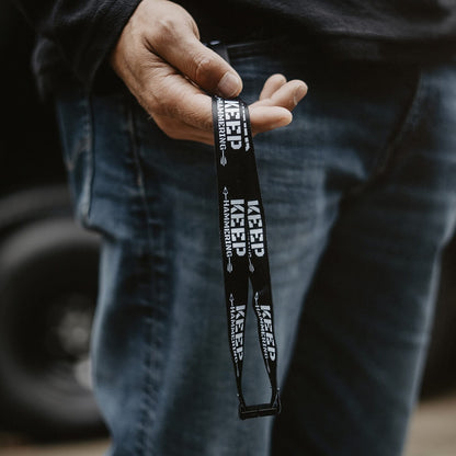 Person holding a black lanyard with 'KEEP' branding.